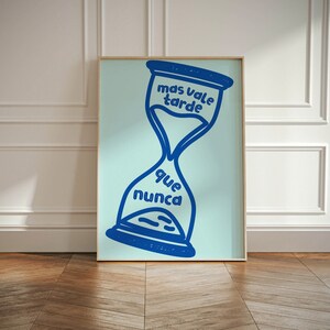 May include: A blue hourglass with the Spanish text "mas vale tarde que nunca" which translates to "better late than never" on a light blue background.