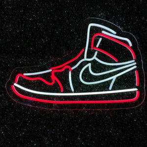 May include: Neon sign of a white and red sneaker with a white swoosh on a black background.