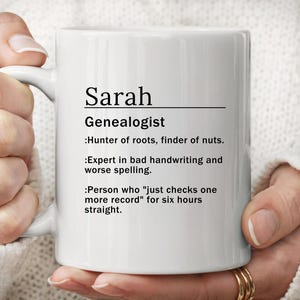May include: White ceramic mug with the name "Sarah" and the title "Genealogist" printed in black. The mug includes humorous definitions of a genealogist, such as "Hunter of roots, finder of nuts."