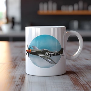 May include: White ceramic mug with a blue circle design featuring a green and gray airplane with red, white, and blue markings. The airplane has the text "BG-S" and "44465" on it.
