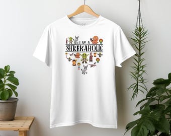 May include: White t-shirt with a green ogre and other characters from the Shrek movies. The text "I am a Shrekaholic" is printed on the shirt.