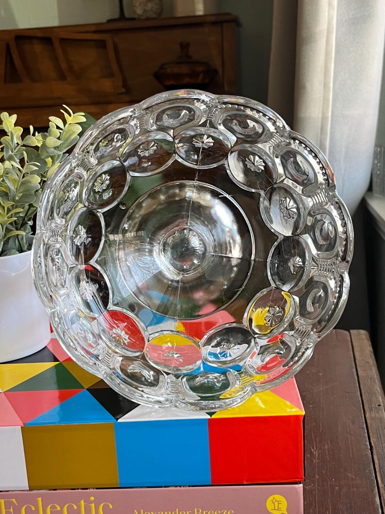 Op de afbeelding: Een glazen kom met een gegolfde rand en een reli&euml;fpatroon van kleine cirkels. De kom is leeg en lijkt vintage te zijn.