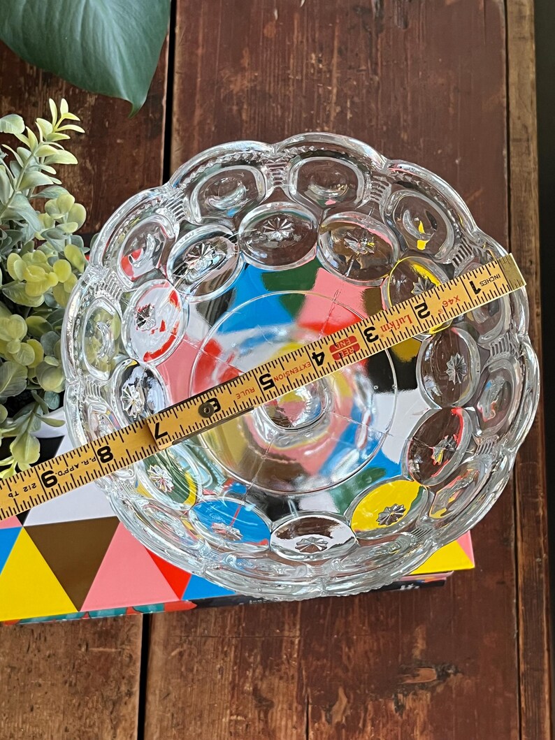 Op de afbeelding: Een glazen kom met een gegolfde rand en een reli&euml;fpatroon van kleine cirkels. De kom is ongeveer 18 cm in diameter.
