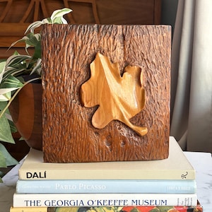 Obra de arte en madera tallada a mano con forma de hoja, firmada y fechada en el '74.