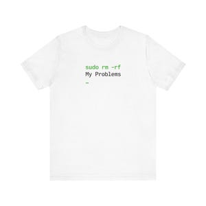 May include: White t-shirt with the text "sudo rm -rf My Problems" in green. The shirt has a crew neck and short sleeves. The text is in a monospace font, resembling a command-line interface.