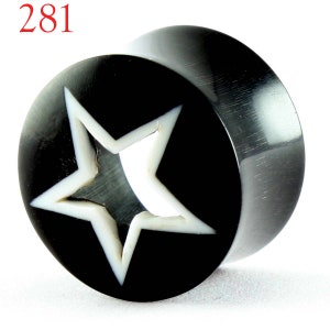 May include: Black and white horn ear gauge with a star design. The star is cut out and the background is black.