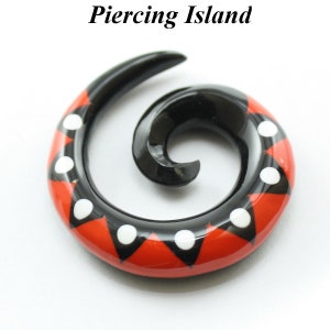 May include: Spiral ear gauge made of black and red acrylic with white polka dots.
