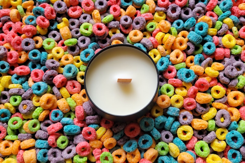 Candle surrounded by Froot Loops cereal.