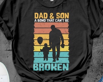 May include: Black t-shirt with a vintage-style graphic that says "Dad & Son A Bond That Can't Be Broken". The graphic features a father and son holding balloons.