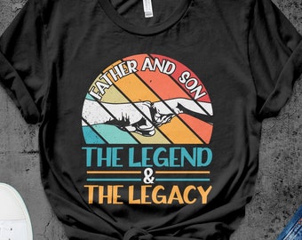 May include: Black t-shirt with a vintage-style graphic that says "Father and Son The Legend & The Legacy". The graphic features two fists bumping, with a rainbow-colored background.