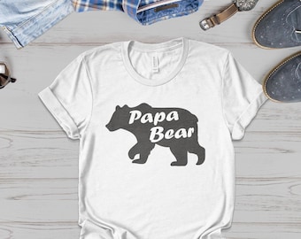 May include: White t-shirt with a black bear silhouette and the text "Papa Bear" in white.