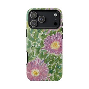 May include: A phone case featuring a floral design. The case has a green background with pink flowers and yellow centers. The case has a black border and a camera cutout.