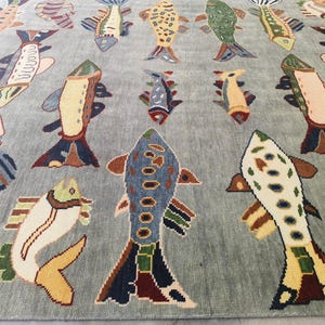May include: A light blue rug featuring a repeating pattern of colourful fish. The fish are in various colours, including yellow, blue, green, and brown. The rug is a decorative item.