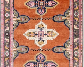 May include: An orange area rug with a central geometric design in shades of blue, pink, and yellow. The rug features a detailed border with floral and bird motifs. The text "RUG AND CRAFT" is visible on the rug.