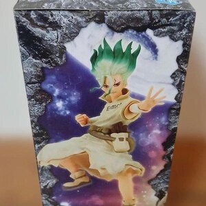 May include: A box featuring a colorful illustration of a character with green hair and a white outfit. The character is in a dynamic pose, with one arm outstretched. The box has a stone-like design on the top and sides.