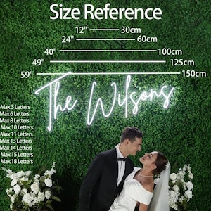 Puede incluir: Un letrero de ne&oacute;n con el texto "The Wilsons" se muestra sobre un fondo verde, con referencias de tama&ntilde;o en pulgadas y cent&iacute;metros. Una pareja se abraza frente al letrero, con flores blancas en primer plano.