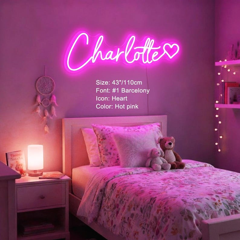 Puede incluir: Un letrero de ne&oacute;n rosa intenso que muestra el nombre Charlotte en letra cursiva con un icono de coraz&oacute;n al final. El letrero mide 110 cm de ancho. El texto en la pared especifica el tama&ntilde;o de 110 cm, la fuente #1 Barcelony y el color rosa.