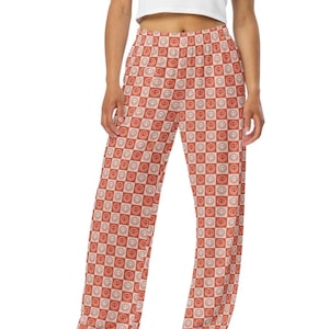 May include: Wide-leg pants with a red and white checkered pattern featuring a repeating smiley face design.