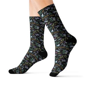 May include: A pair of black socks with a floral pattern in shades of blue, green, and purple. The socks are made of a soft, comfortable material and are perfect for everyday wear.