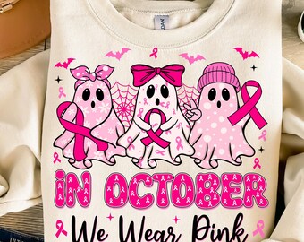 May include: A white sweatshirt with a pink and white design of three ghosts wearing pink ribbons. The text "In October We Wear Pink" is printed below the ghosts.