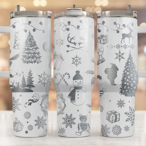 May include: Three white stainless steel tumblers with a black and white Christmas design. The tumblers have a handle and a lid. The designs include a snowman, a Christmas tree, a reindeer, and snowflakes.