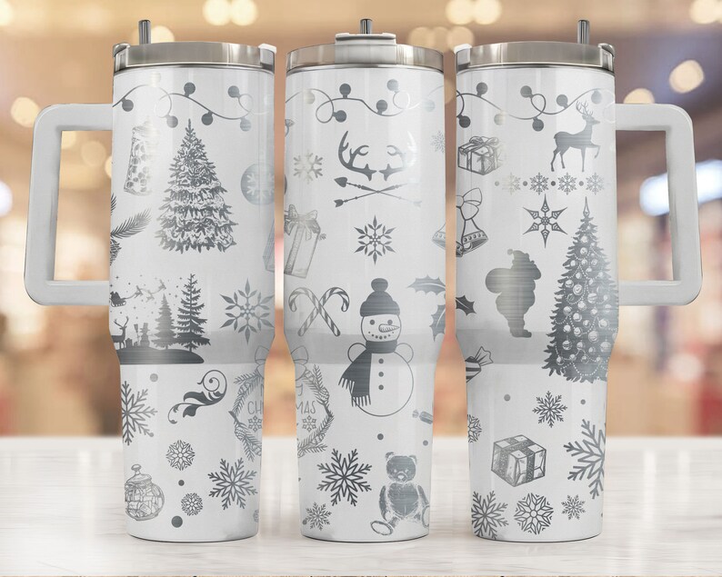 May include: Three white stainless steel tumblers with a black and white Christmas design. The tumblers have a handle and a lid. The designs include a snowman, a Christmas tree, a reindeer, and snowflakes.