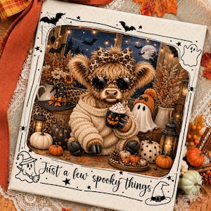 May include: A square decorative sign featuring a fluffy Highland cow wearing leopard print sunglasses and a matching bow, holding a pumpkin-faced mug. The scene includes pumpkins, a ghost, and lanterns, with the text Just a few spooky things.