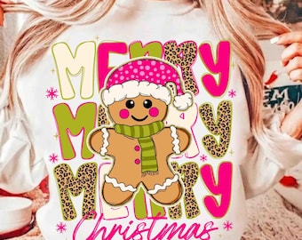 May include: White sweatshirt with a festive "Merry Christmas" design. The graphic features a gingerbread man wearing a pink polka-dot hat and green scarf, surrounded by pink and leopard print letters and snowflakes.