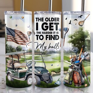 May include: A set of three stainless steel tumblers with a golf theme. The tumblers feature a green golf course, a golf cart, golf clubs, and the text "The older I get the harder it is to find my balls".