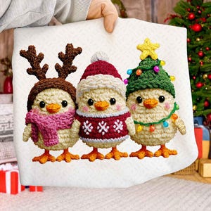 May include: Three crocheted chick ornaments, each dressed for the holidays. One wears reindeer antlers and a pink scarf, another a Santa hat and sweater, and the last a Christmas tree hat with lights. The chicks are held against a white background.