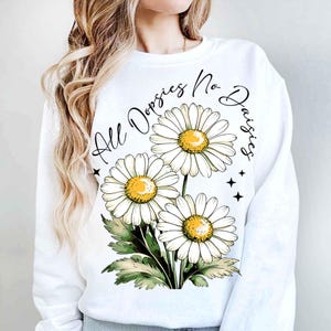 May include: White sweatshirt with a graphic of three white daisies and the text "All Doppsies No Daisies".