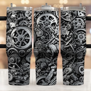May include: A black and white stainless steel tumbler featuring a design of interlocking gears. The tumbler has a black lid and a black handle.