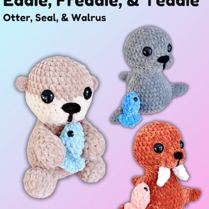 May include: Three crocheted stuffed animals: an otter, a seal, and a walrus. The otter is brown and holding a blue fish. The seal is gray and holding a blue fish. The walrus is brown and holding a pink fish. The animals are all sitting on a pink and blue background. Eddie, Freddie, & Teddy. Otter, Seal, & Walrus.