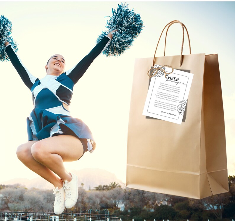 May include: A brown paper gift bag with a white card attached to it. The card has the text "Cheer Prayer" and a floral design. A cheerleader is jumping in the air in the background.