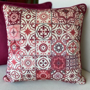 May include: A decorative throw pillow with a patchwork design featuring red, white, and brown geometric patterns. The pillow is made of a soft, textured fabric.