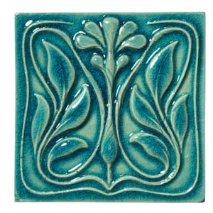 Könnte beinhalten: Quadratische türkisfarbene Keramikfliese mit erhabenem floralem Design. Die Fliese zeigt eine zentrale stilisierte Blume und symmetrische Blättermuster. Die glänzende Oberfläche und die Craquelé-Textur sorgen für visuelles Interesse.