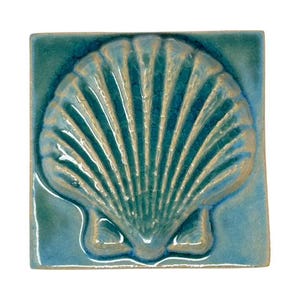 Könnte beinhalten: Quadratische Keramikfliese mit erhabenem Muscheldesign. Die Fliese ist türkis mit einer helleren, goldbraunen Muschel. Die Muschel hat detaillierte Rippen und ist auf der quadratischen Fliese zentriert.