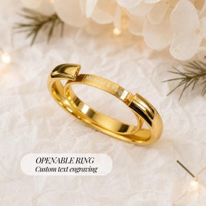 Peut inclure: Une bague ouvrante dorée polie dotée d'un mécanisme à charnière et d'une surface extérieure plate gravée avec le texte Micheal & Paige. La bague présente une finition métallique lisse et réfléchissante ainsi qu'une forme circulaire articulée.