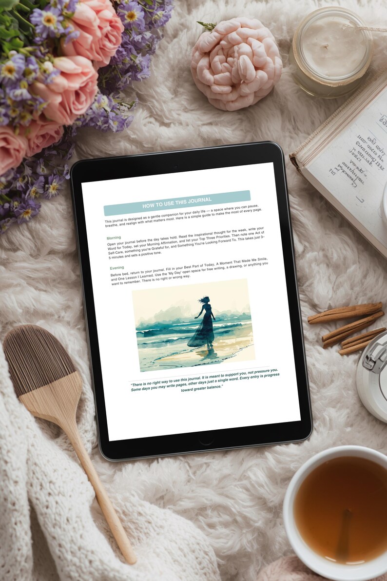 Op de afbeelding: Een digitale tablet met een journaalpagina met instructies en een aquarel illustratie van een persoon op een strand. De afbeelding is omgeven door bloemen, een kaars, een boek en een kopje thee.