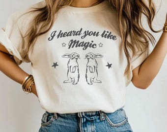 May include: A white t-shirt with the text "I heard you like magic" and two rabbits printed on the front.