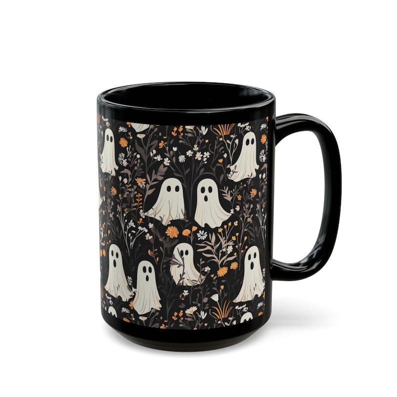May include: Black coffee mug with a white ghost and floral pattern. The mug has a black handle and a white interior.