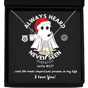 May include: A black box with a silver necklace inside. The necklace features a silver heart with a gold outline and a small clear crystal. The box has a black background with white text that reads "Always Heard Never Seen Dispatch Julie #177...and the most important person in my life. I love You!"