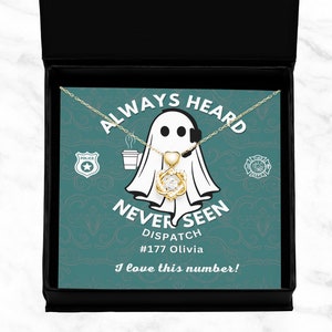 May include: A white ghost with a headset and a coffee cup, holding a gold necklace with a heart and a crystal. The text reads "Always Heard Never Seen Dispatch #177 Olivia I love this number!"
