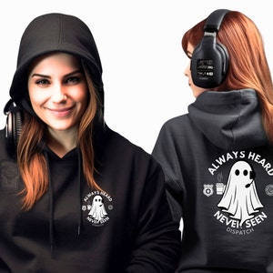 May include: Black hooded sweatshirt with a white ghost graphic on the front and back. The ghost is wearing a headset and holding a cup of coffee. The text on the front reads "Always Heard Never Seen". The text on the back reads "Always Heard Never Seen Dispatch".