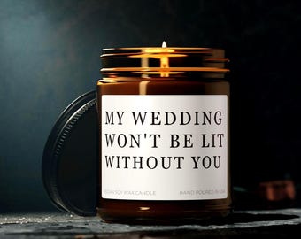 Op de afbeelding: Een bruine glazen kaars pot met een wit label waarop staat "MY WEDDING WON'T BE LIT WITHOUT YOU". De kaars is een veganistische sojawas kaars en is met de hand gegoten in de VS.