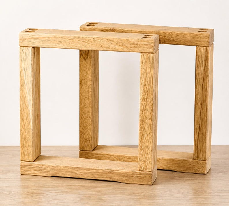 May include: Two rectangular furniture legs crafted from light-colored natural wood with a visible grain pattern. Each leg features a sturdy frame construction with four pre-drilled circular holes on the top horizontal bar for mounting purposes.
