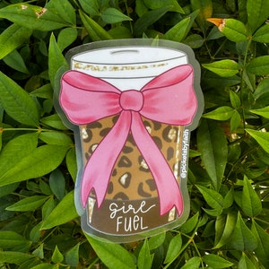 May include: A clear sticker with a brown and black leopard print design. The sticker features a pink bow and the text "Girl Fuel".