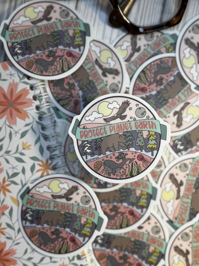 May include: A set of round stickers with a pastel pink background and a green border. The stickers feature a whimsical illustration of a bear, whale, and flying bird with the text "Protect Planet Earth" in a banner.