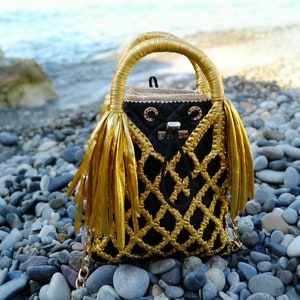 A small bright evening bag for a young woman.Handbag for the phone. Macramé with golden cord.