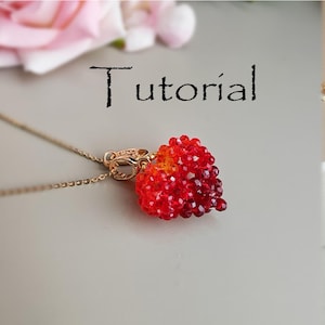 May include: A gold necklace featuring a heart-shaped pendant crafted from red and orange beads. The pendant is attached to a gold chain with a decorative clasp. The word "Tutorial" is written above the necklace.